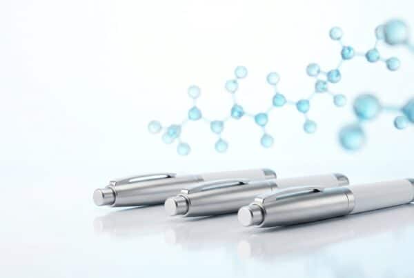 Trois stylos injecteurs pharmaceutiques GLP-1 alignés représentant les trois générations sémaglutide tirzépatide retatrutide, comparatif scientifique 2026